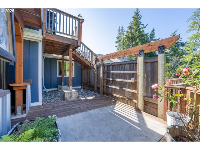 a view of a patio with table and chairs with wooden floor and fence