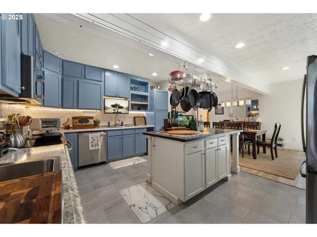 a kitchen with stainless steel appliances kitchen island granite countertop a sink counter space and cabinets