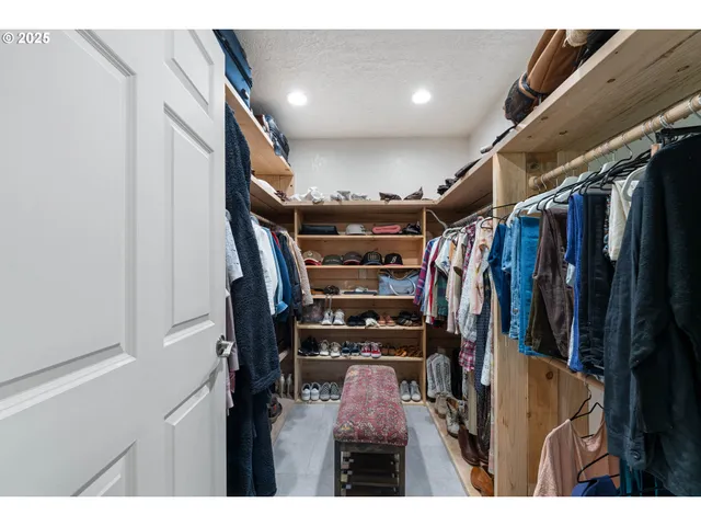 a view of walk in closet with clothes and shoes