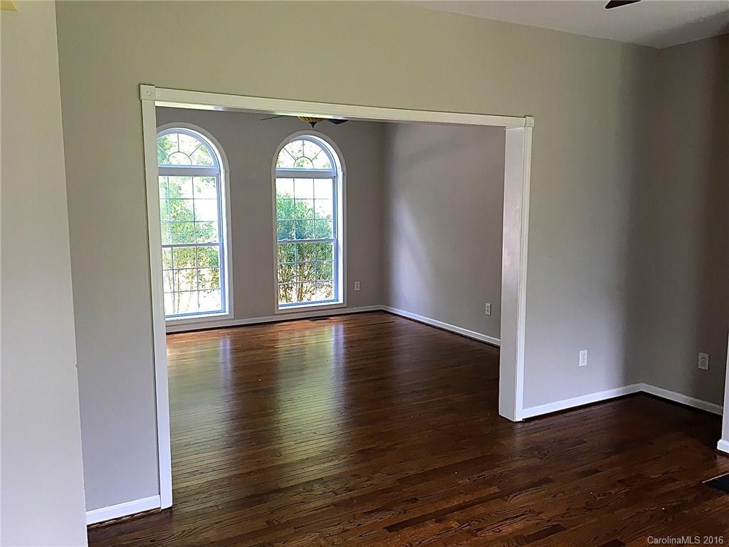 49487 Quail Trail Road Norwood, NC 28128 - Photo 11 of 24 an empty room with wooden floor and windows