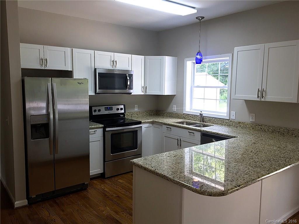 49487 Quail Trail Road Norwood, NC 28128 - Photo 5 of 24 a kitchen with granite countertop a sink stove and refrigerator