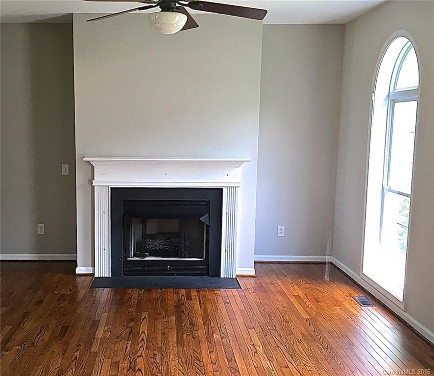 49487 Quail Trail Road Norwood, NC 28128 - Photo 10 of 24 a view of empty room with wooden floor and fireplace
