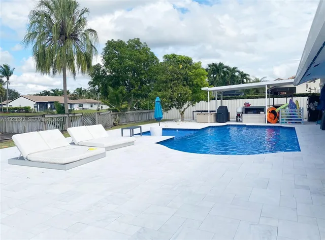 a view of house with swimming pool and sitting area