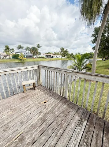 a view of a balcony with chairs and wooden floor