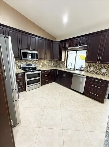 a kitchen with stainless steel appliances a stove a sink and a refrigerator