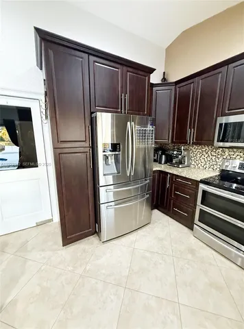 a kitchen with stainless steel appliances granite countertop a refrigerator and a stove