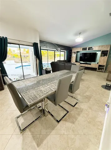 a living room with furniture a flat screen tv and a large window