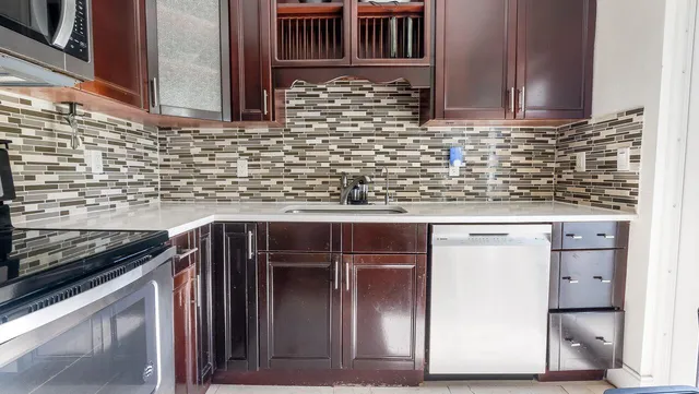 a kitchen with stainless steel appliances a stove a sink and a microwave