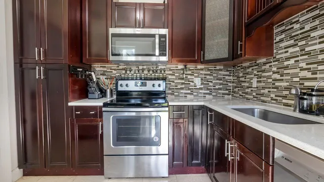 a bedroom with a bed wooden floor and a large window
