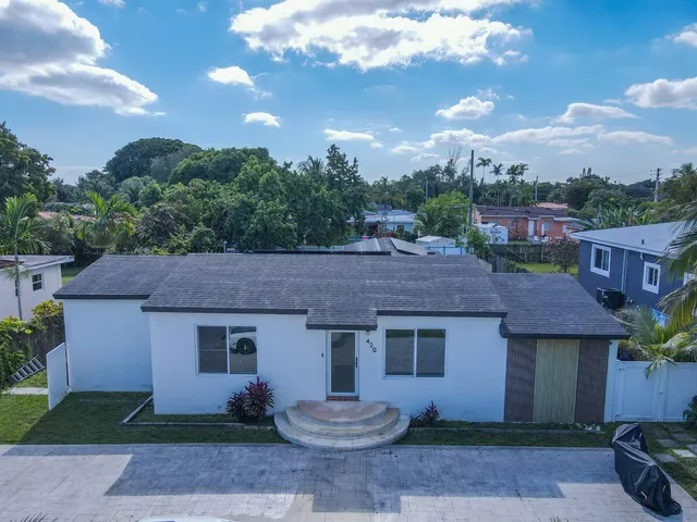 a aerial view of a house with a yard and potted plants