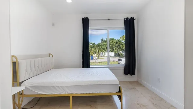 a bedroom with a bed and a large window