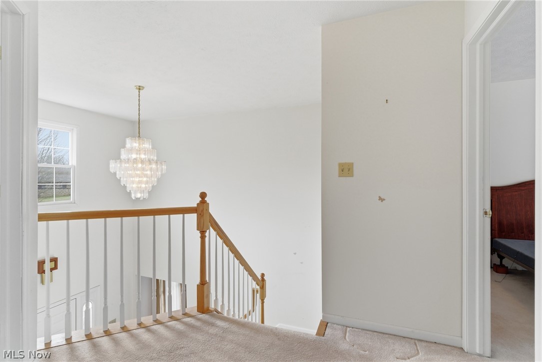 25684 Tryon Road Bedford, OH 44146 - Photo 10 of 19 Corridor featuring light colored carpet, hanging lights, and an upstairs landing