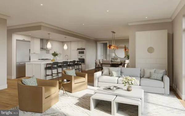 a living room with couches a coffee table and kitchen view with wooden floor