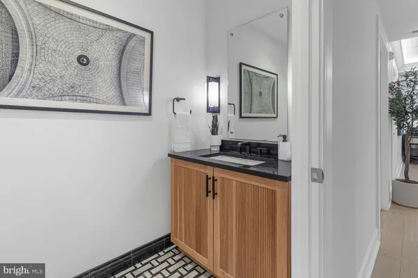a bathroom with a granite countertop bathtub sink vanity mirror and toilet