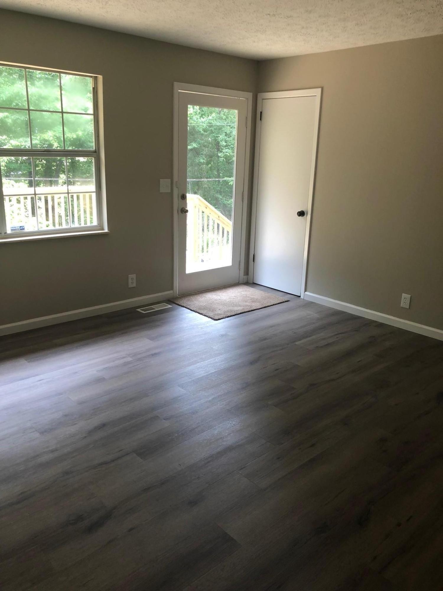 114 Oak Road Powell, TN 37849 - Photo 4 of 12 an empty room with wooden floor and windows