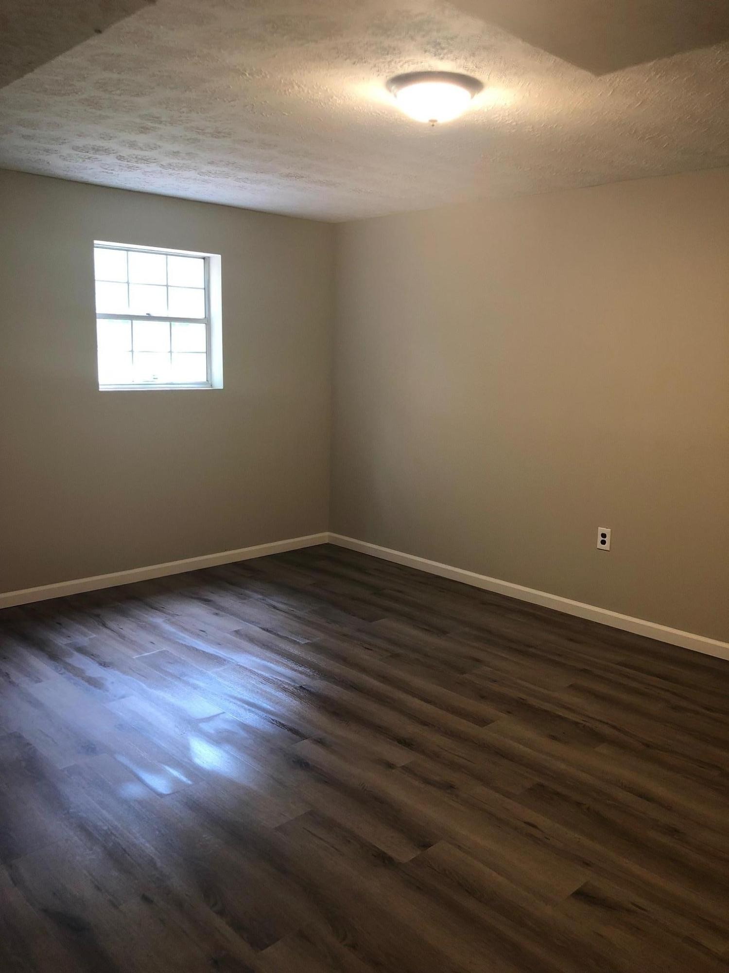 114 Oak Road Powell, TN 37849 - Photo 10 of 12 a view of an empty room with wooden floor and a window