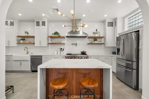 a kitchen with stainless steel appliances granite countertop a sink refrigerator and cabinets