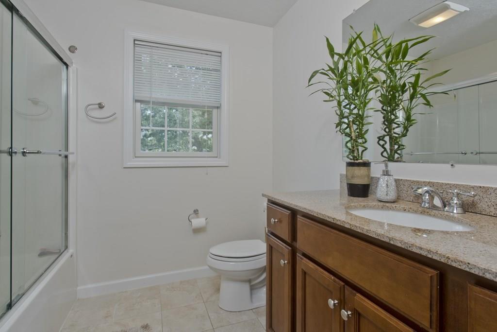 39 Spencer Street Springfield, MA 01118 - Photo 18 of 30 a bathroom with a granite countertop sink a toilet and with mirror