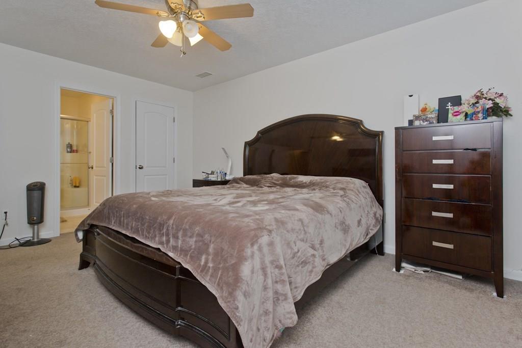 39 Spencer Street Springfield, MA 01118 - Photo 5 of 30 a spacious bedroom with a bed and a chandelier