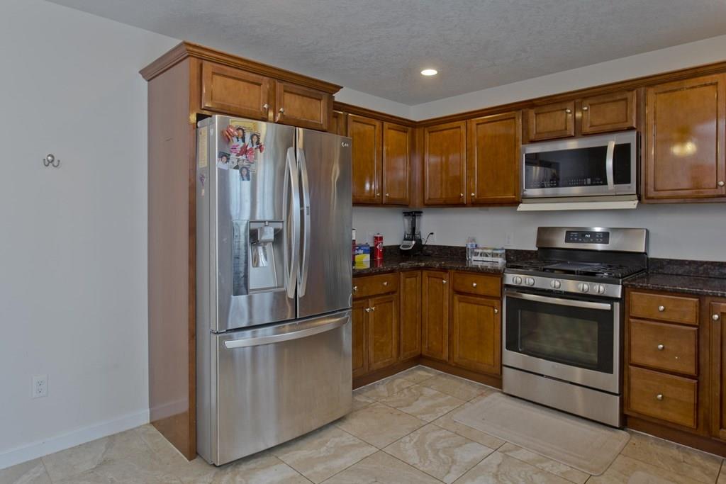 39 Spencer Street Springfield, MA 01118 - Photo 9 of 30 a kitchen with stainless steel appliances granite countertop a refrigerator stove and microwave
