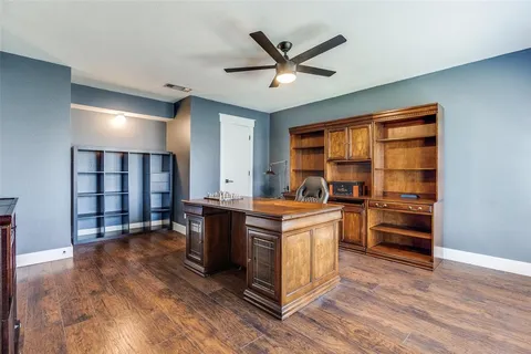 a living room with stainless steel appliances kitchen island hardwood floor and a ceiling fan