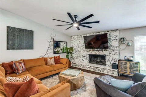 a living room with furniture a flat screen tv and a fireplace