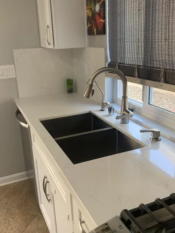 a room with white cabinets and sink