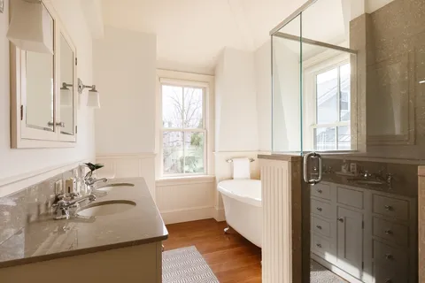a bathroom with a granite countertop sink mirror and a bathtub