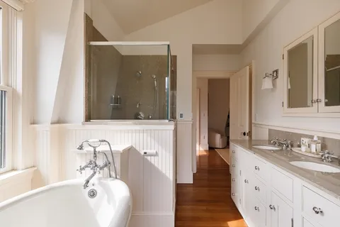 a bathroom with a tub sink and mirror