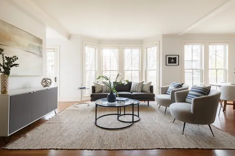 a living room with furniture a rug and a window