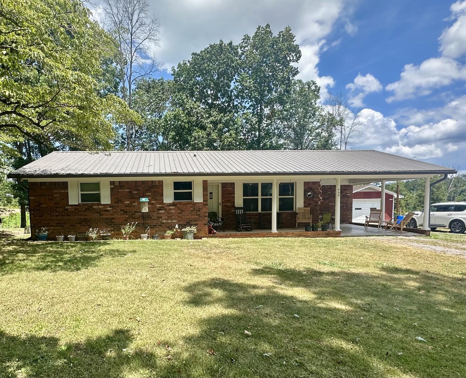 a front view of house with yard outdoor seating and barbeque oven