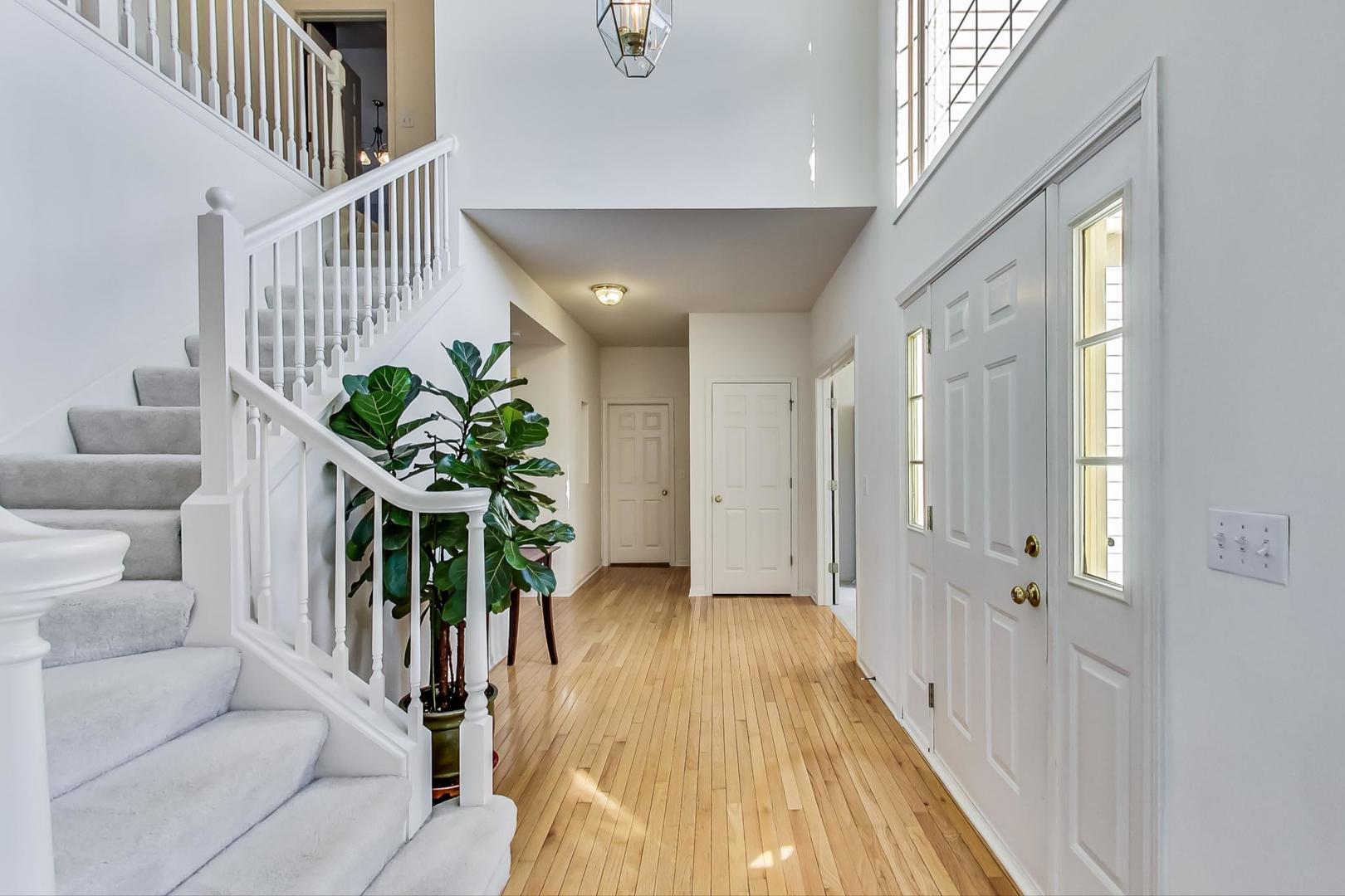 1552 Southgate Road Bartlett, IL 60103 - Photo 2 of 27 a hallway with wooden floor and a potted plant