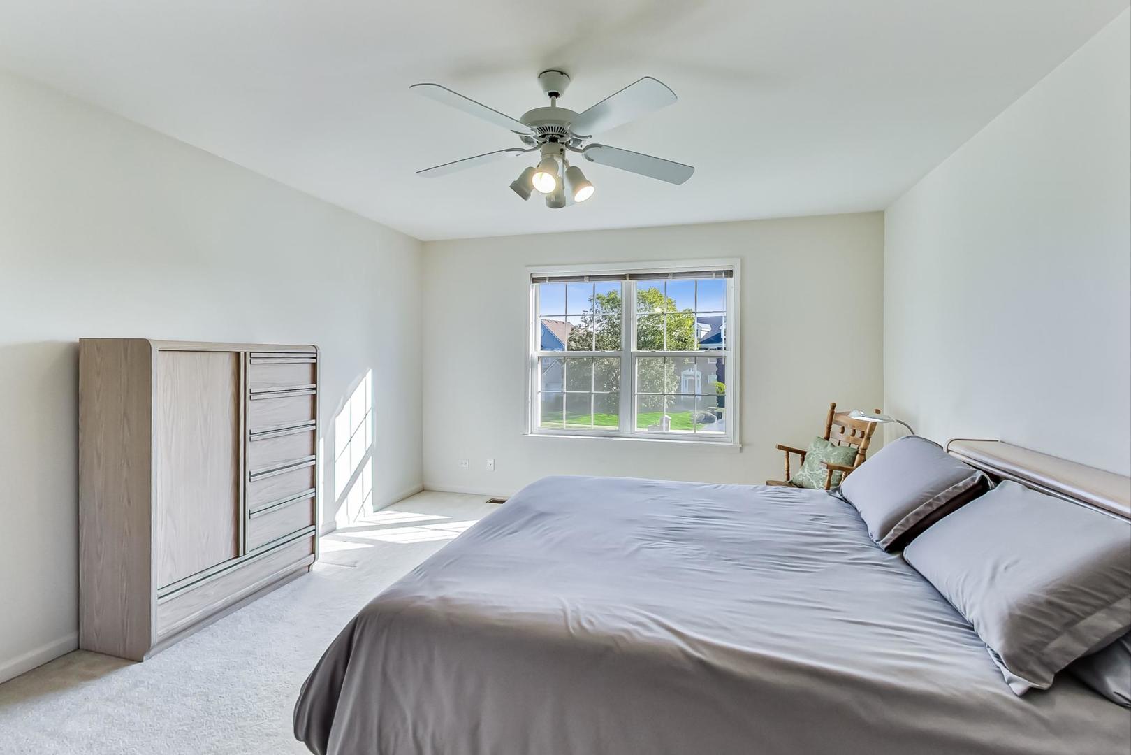 1552 Southgate Road Bartlett, IL 60103 - Photo 18 of 27 a bedroom with a large bed and a chandelier