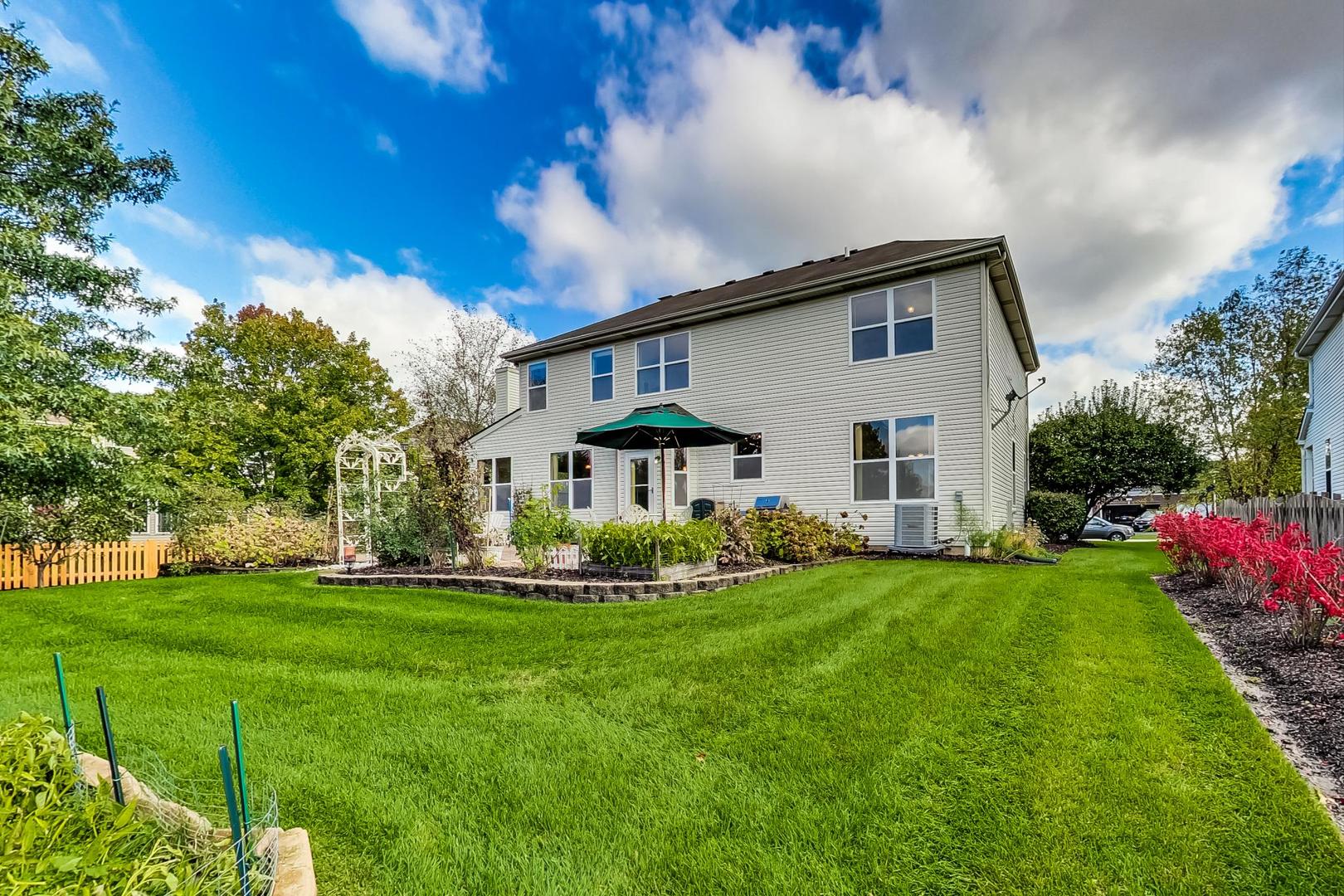 1552 Southgate Road Bartlett, IL 60103 - Photo 24 of 27 a view of a house with a big yard potted plants and large tree