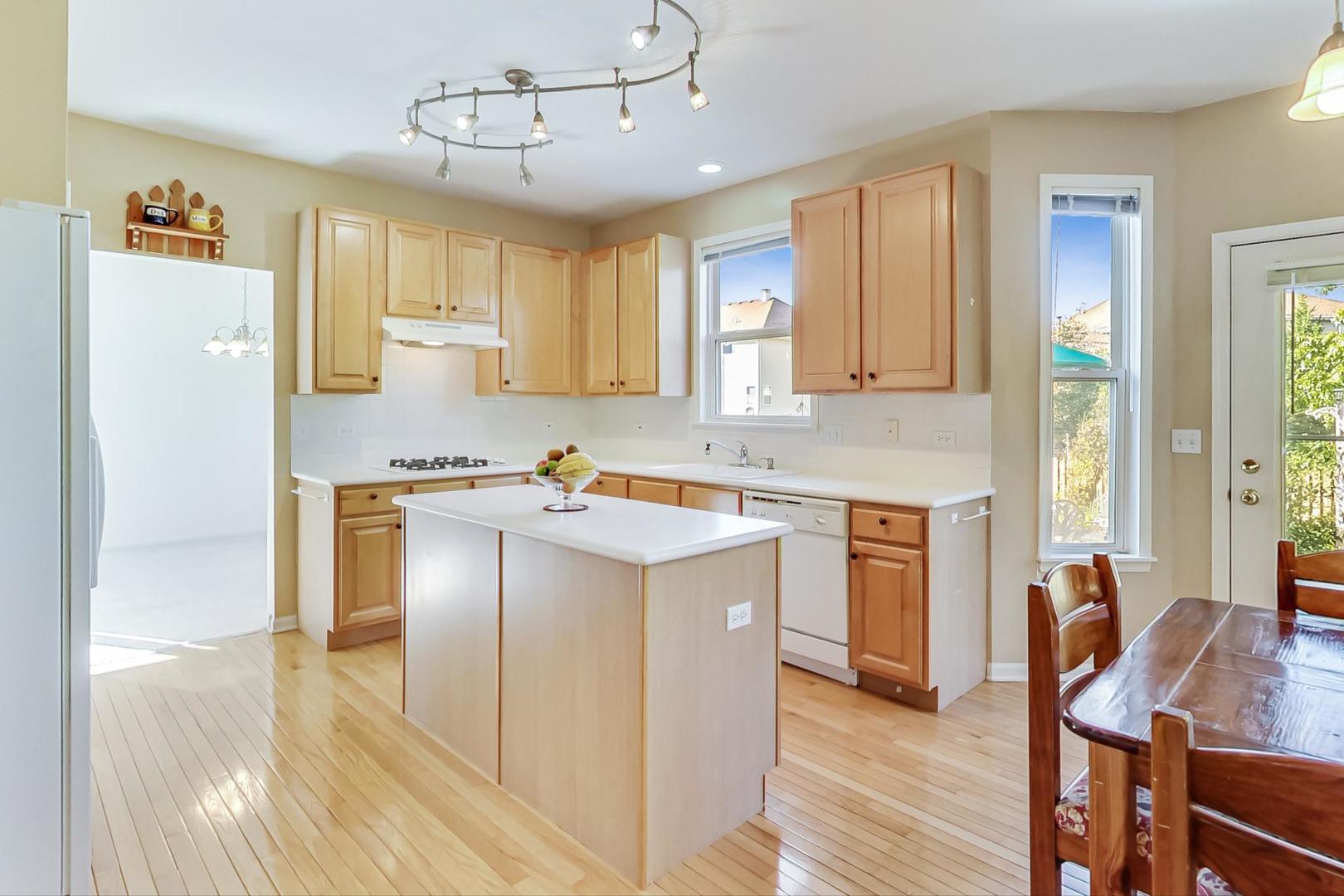 1552 Southgate Road Bartlett, IL 60103 - Photo 8 of 27 a kitchen with a refrigerator a stove cabinets and wooden floor