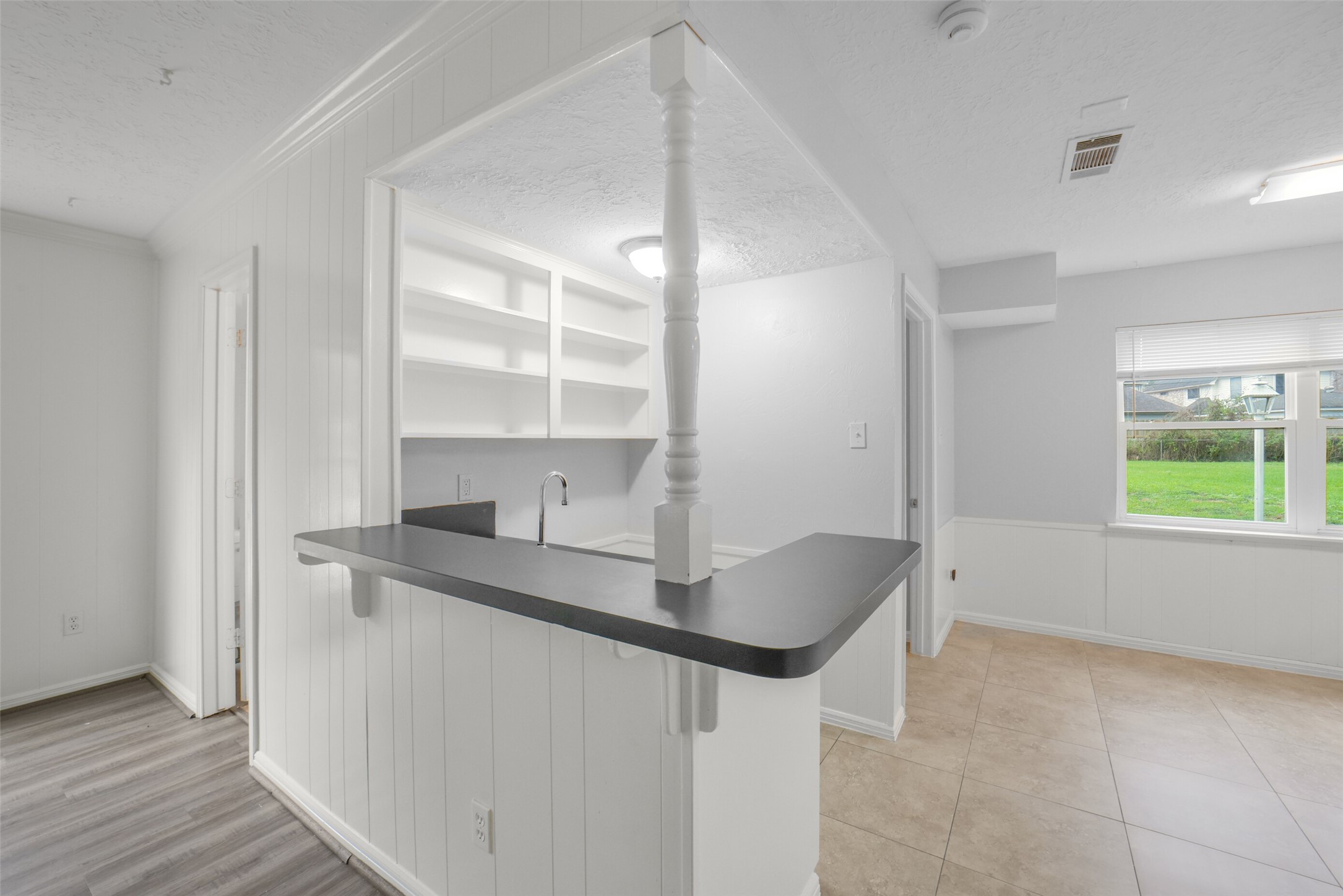 7611 Theisswood Road Spring, TX 77379 - Photo 8 of 41 Wet bar with wood cabinetry, built-in storage, and open shelving.