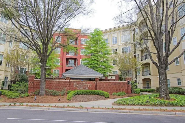 a view of a street in front of a brick house with large windows