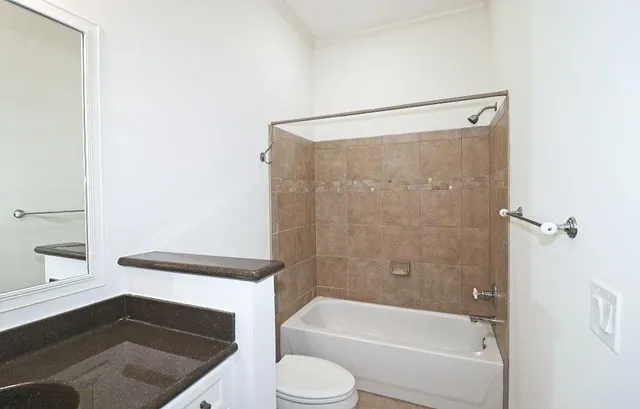 a bathroom with a sink a toilet a bathtub and shower