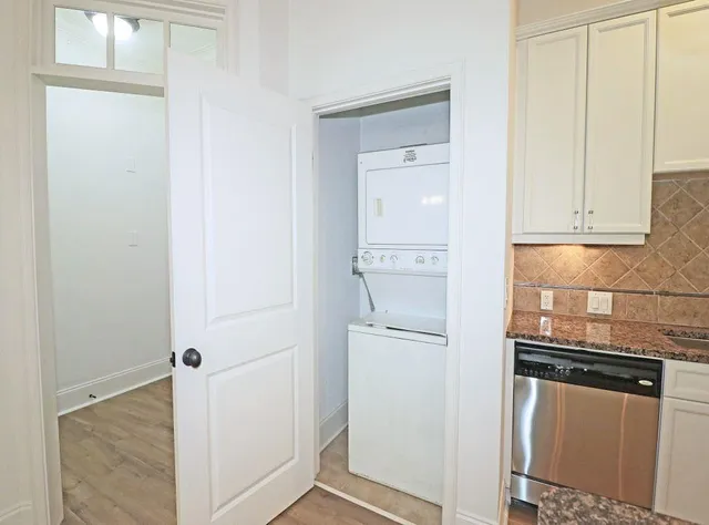 a view of a kitchen with white cabinets and a refrigerator