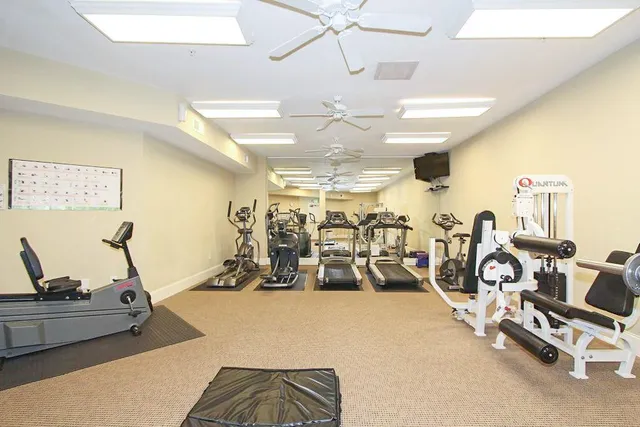 a living room with furniture gym equipment and a chandelier