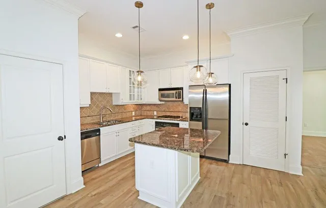 a kitchen with stainless steel appliances granite countertop a refrigerator a sink and a stove