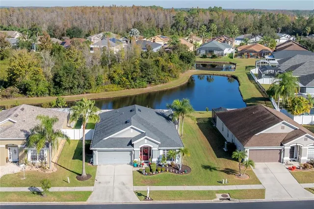 an aerial view of residential houses with outdoor space and parking