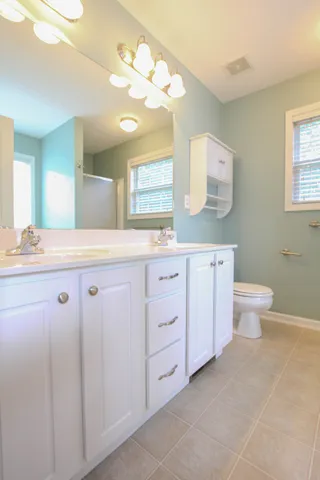 a bathroom with a granite countertop sink a toilet and a mirror
