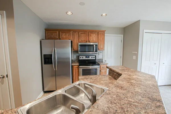 a kitchen with granite countertop a refrigerator and a sink