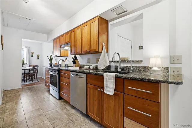a kitchen with kitchen island granite countertop a sink counter top space and cabinets