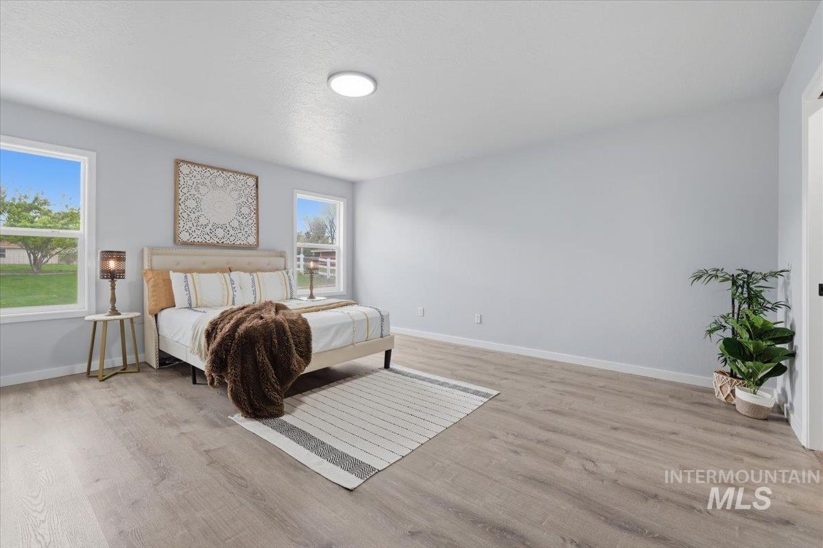 25022 Tumbleweed Road Middleton, ID 83644 - Photo 15 of 41 Bedroom with light wood finished floors and baseboards