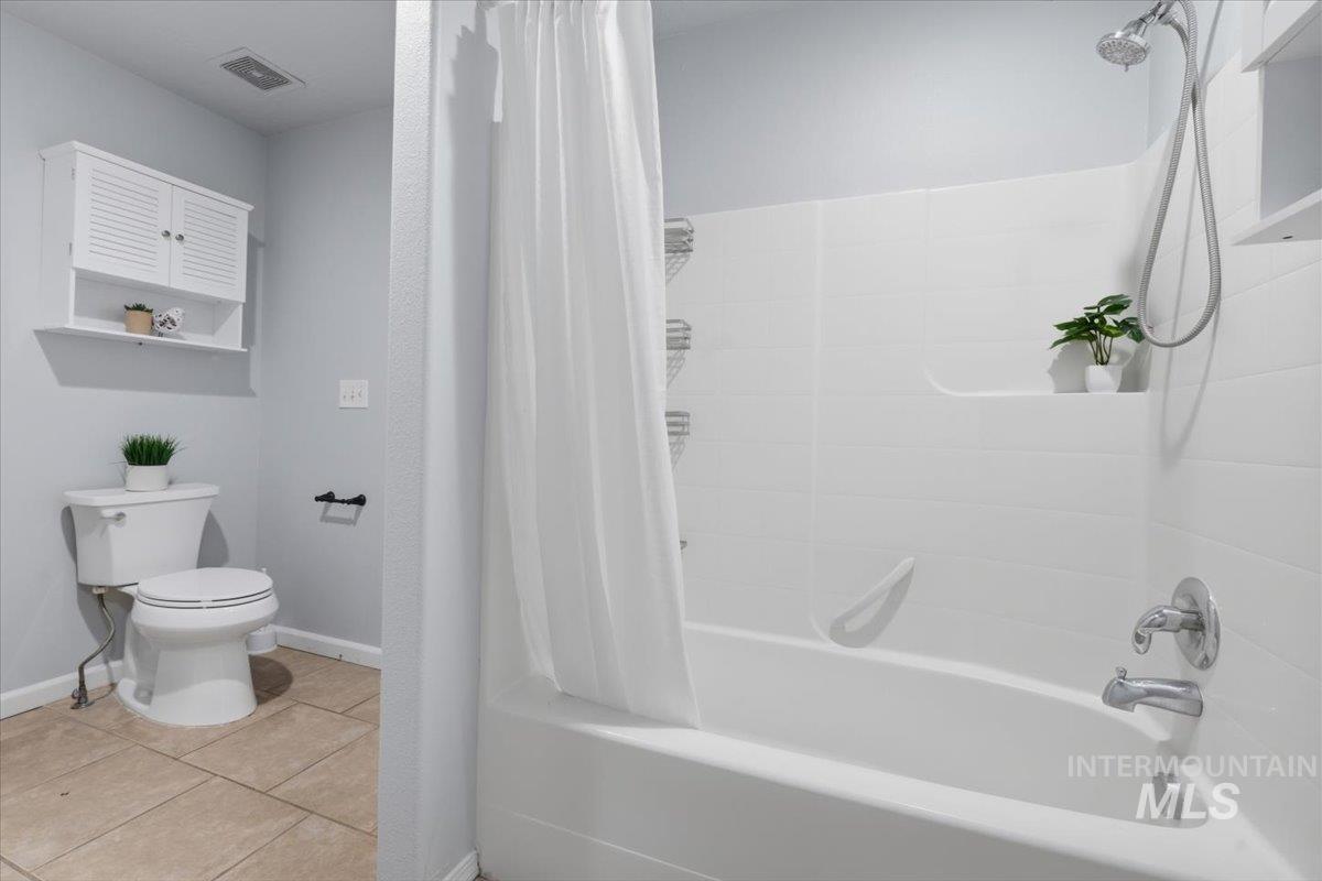 25022 Tumbleweed Road Middleton, ID 83644 - Photo 26 of 41 Full bathroom featuring light tile patterned floors and shower / tub combo with curtain