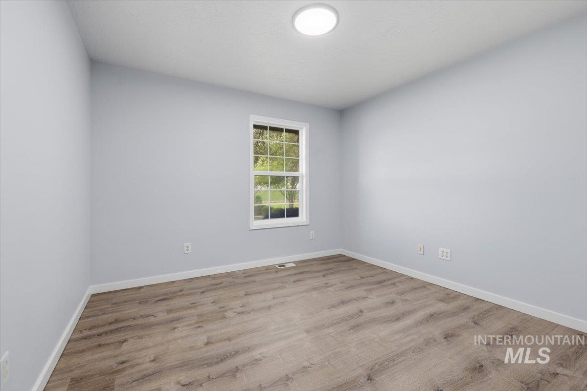 25022 Tumbleweed Road Middleton, ID 83644 - Photo 29 of 41 Empty room featuring light wood-style flooring and baseboards