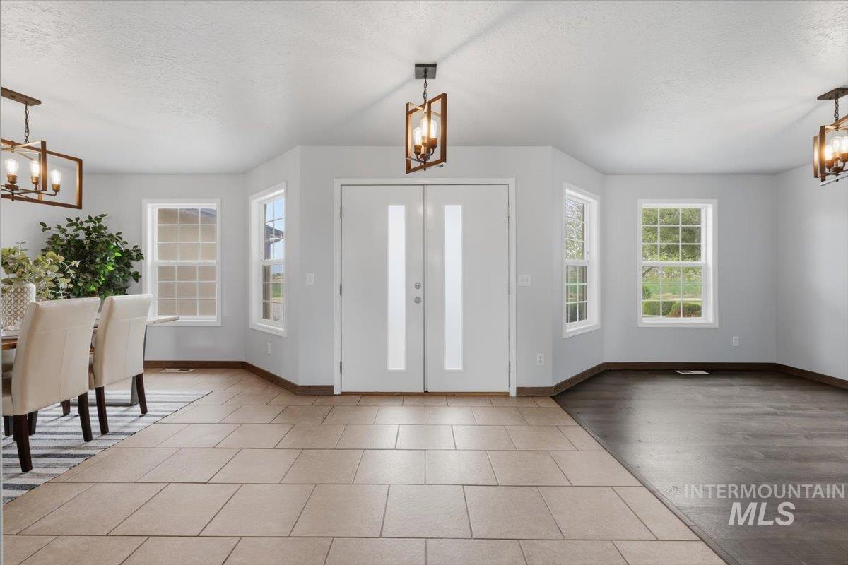 25022 Tumbleweed Road Middleton, ID 83644 - Photo 4 of 41 Entryway with suspended lighting, a textured ceiling, and light tile patterned flooring