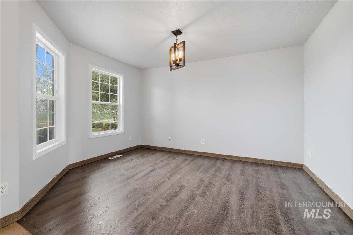25022 Tumbleweed Road Middleton, ID 83644 - Photo 6 of 41 Unfurnished room featuring light wood finished floors and suspended lighting